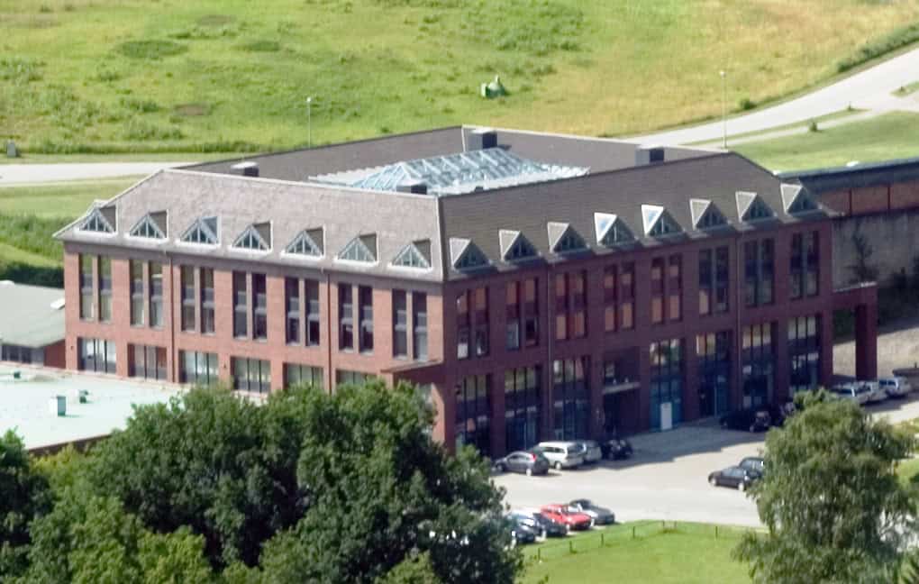 Modernes Backstein-Bürogebäude mit Parkplatz, Luftaufnahme